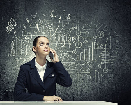 Young upset businesswoman talking on mobile phoneの写真素材