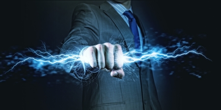 Businessman holding lightning in fist  Power and controlの写真素材
