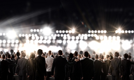 Crowd of businesspeople standing with back with lights at backgroundの写真素材