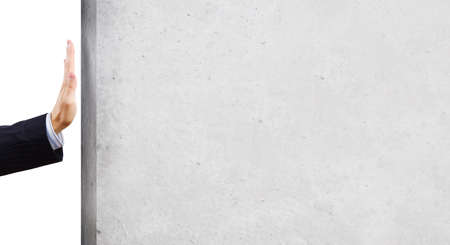 Businessman touching stone grey wall with palmの写真素材