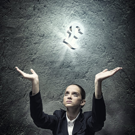 Young businesswoman praying at pound symbol above headの写真素材