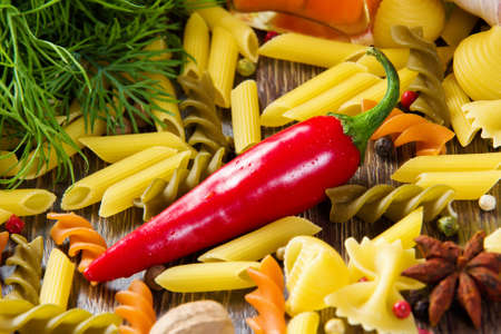 Chilli pepper macaroni herbs and splices on kitchen tableの写真素材