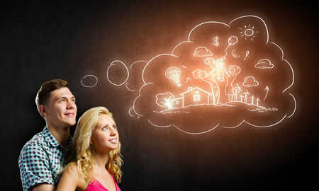 Conceptual image of young couple hugging each other and dreamingの写真素材