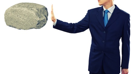 Businessman in suit huge holding stone in palmの写真素材