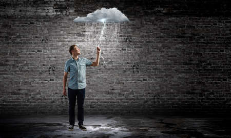 Young man touching illustration of raining cloudの写真素材