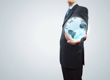 Young businessman holding Earth planet in palmの写真素材