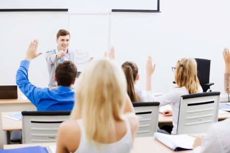 Young teacher in classroom standing in front of classの写真素材
