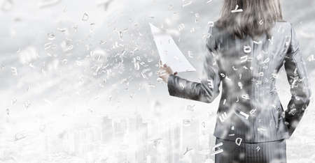 Back view of businesswoman holding papers in handsの写真素材