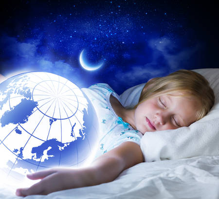 Girl in bed with Earth planet in hands  の写真素材
