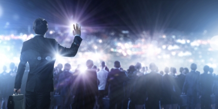 Back view of businessman speaker standing on podium in lightsの写真素材