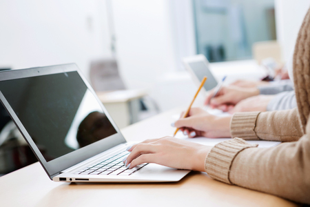 Close up image of young people using laptop at classroomの写真素材