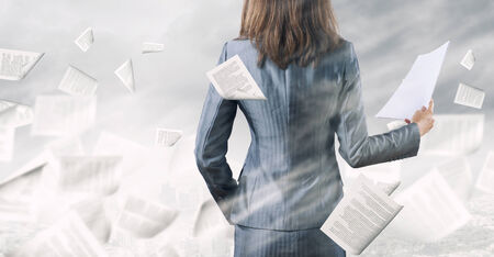 Back view of businesswoman holding papers in handsの写真素材