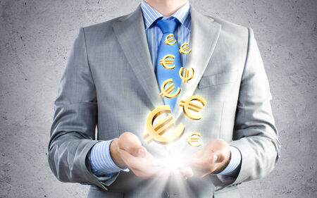 Close up of businessman holding euro symbols in palmsの写真素材