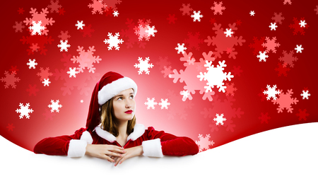 Young attractive woman in santa suit holding blank banner  Place for textの写真素材