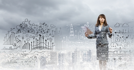 Businesswoman drawing business plan and sketches with markerの写真素材