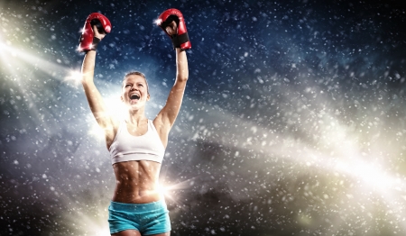 Young pretty boxer woman standing in light flashesの写真素材
