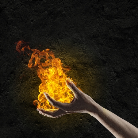 Close up of human hand holding fire flameの写真素材