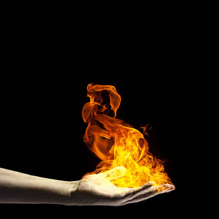 Close up of human hand holding fire flameの写真素材