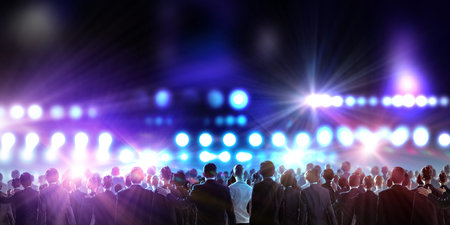 Crowd of businesspeople standing with back with lights