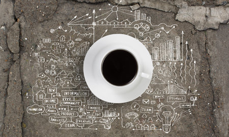 Cup of coffee with sketches at backgroundの写真素材