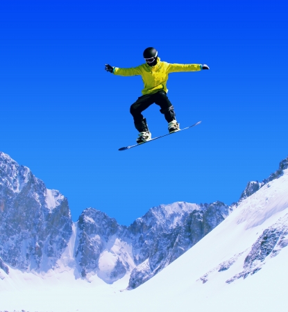 Snowboarder making jump high in clear skyの写真素材