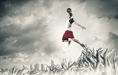 Young man basketball player with ball in hands jumping high
