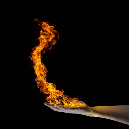 Close up of human hand holding fire flameの写真素材