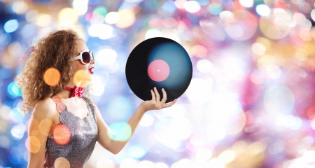 Young pretty girl dj at disco party holding vinylの写真素材