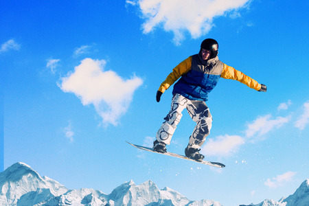 Snowboarder making jump high in clear skyの写真素材