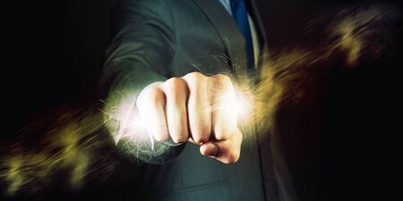 Businessman holding lightning in fist  Power and controlの写真素材