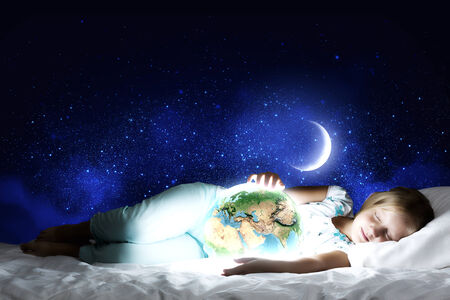 Girl in bed with Earth planet in hands  Elements of this image are furnished by NASAの写真素材