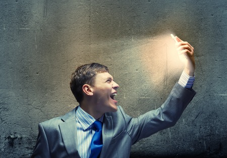 Angry businessman screaming furiously in to mobile phoneの写真素材