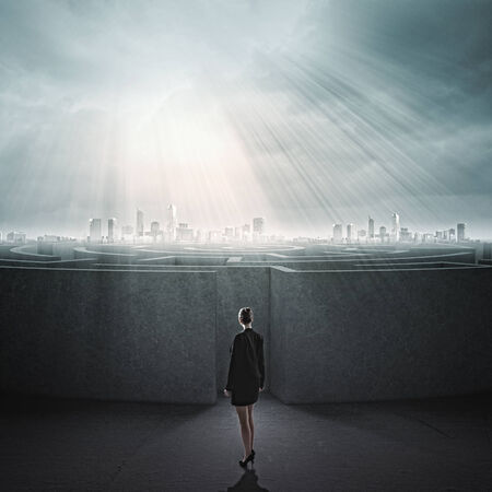 Businesswoman standing near the enter of labyrinthの写真素材