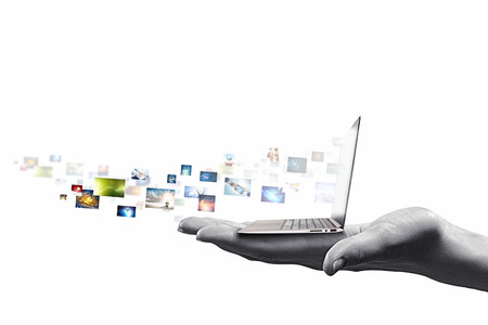 Close up of hand with laptop and media iconsの写真素材