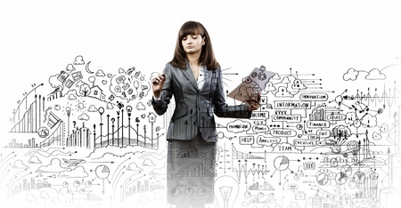 Businesswoman drawing business plan and sketches with markerの写真素材