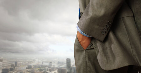 Close up of businessman standing on top viewing at cityの写真素材