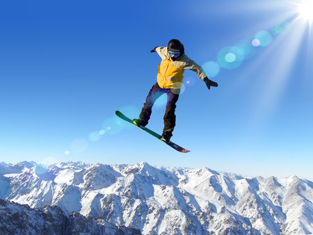 Snowboarder making jump high in clear skyの写真素材