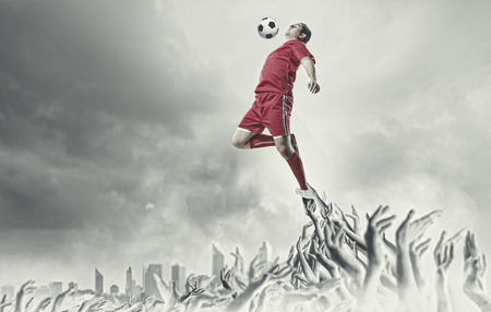 Football player in jump kicking the ballの写真素材