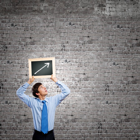 Handsome businessman holding frame with graph drawingの写真素材