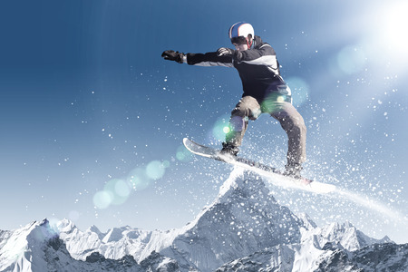 Snowboarder making jump high in clear skyの写真素材