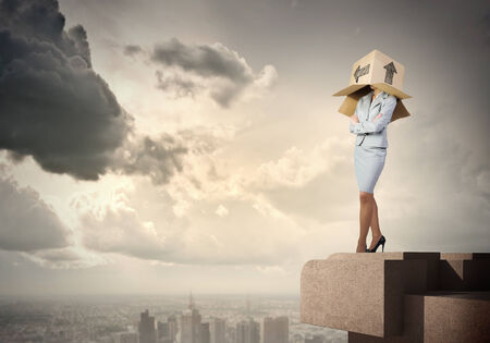 Businesswoman wearing carton box with drawings on headの写真素材