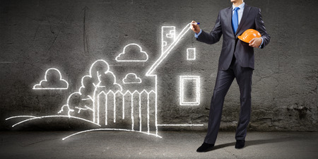 Young man engineer in helmet drawing construction projectの写真素材