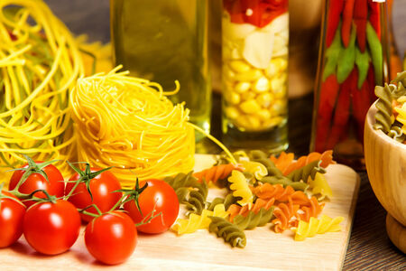 Cherry tomatoes and vegetables on kitchen tableの写真素材