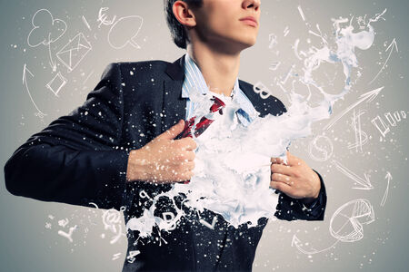 Businessman acting like tearing shirt on chestの写真素材