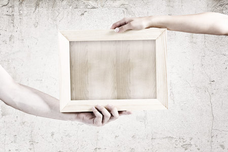 Close up of human hands holding blank frame