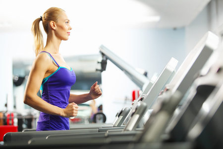 Image of fitness girl running on treadmill