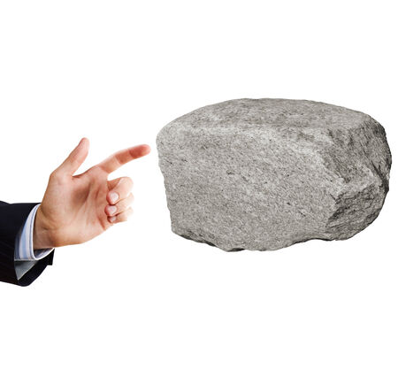 Businessman in suit pointing at huge stoneの写真素材