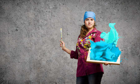 Young woman painter with palette and brush