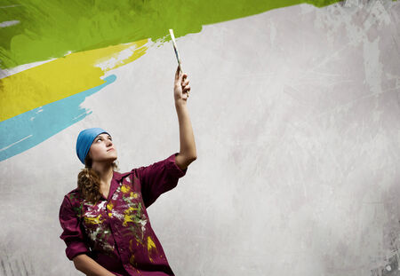 Young woman painter in bandana with paintbrush in handの写真素材