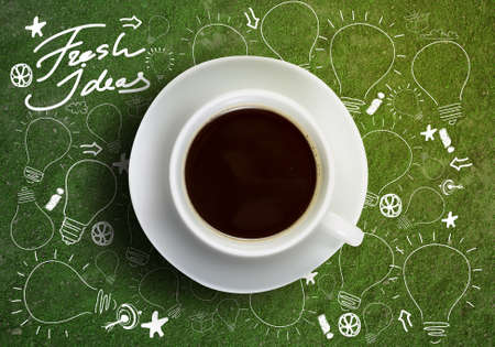 Close up of cup of coffee on table with sketches on backgroundの写真素材